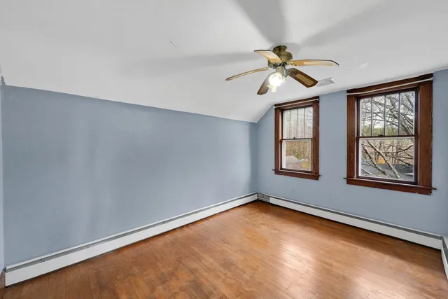 an empty room with windows and fan