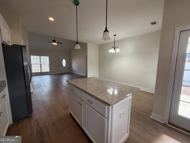 a view of a kitchen counter space wooden floor and a ceiling fan