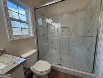 a bathroom with a shower a toilet and a sink