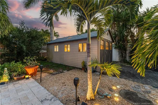 a living room with furniture a chandelier and a potted plant