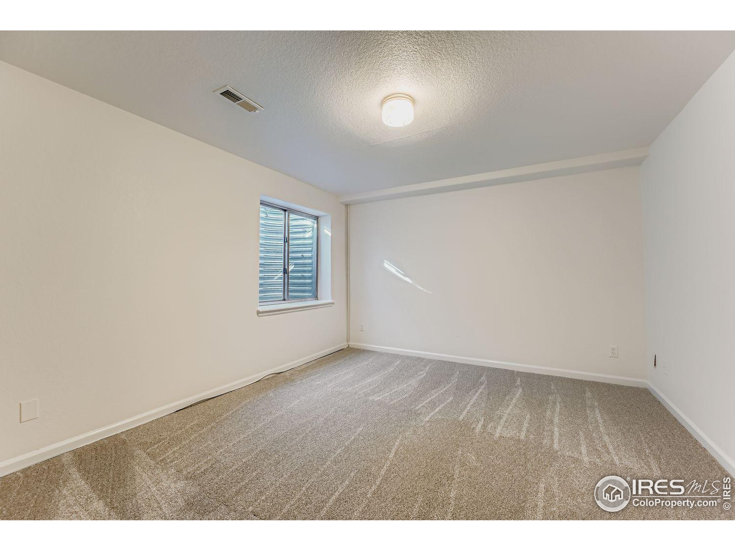 2062 Ridgeview Drive Longmont, CO 80504 - Photo 23 of 29 an empty room with wooden floor and windows
