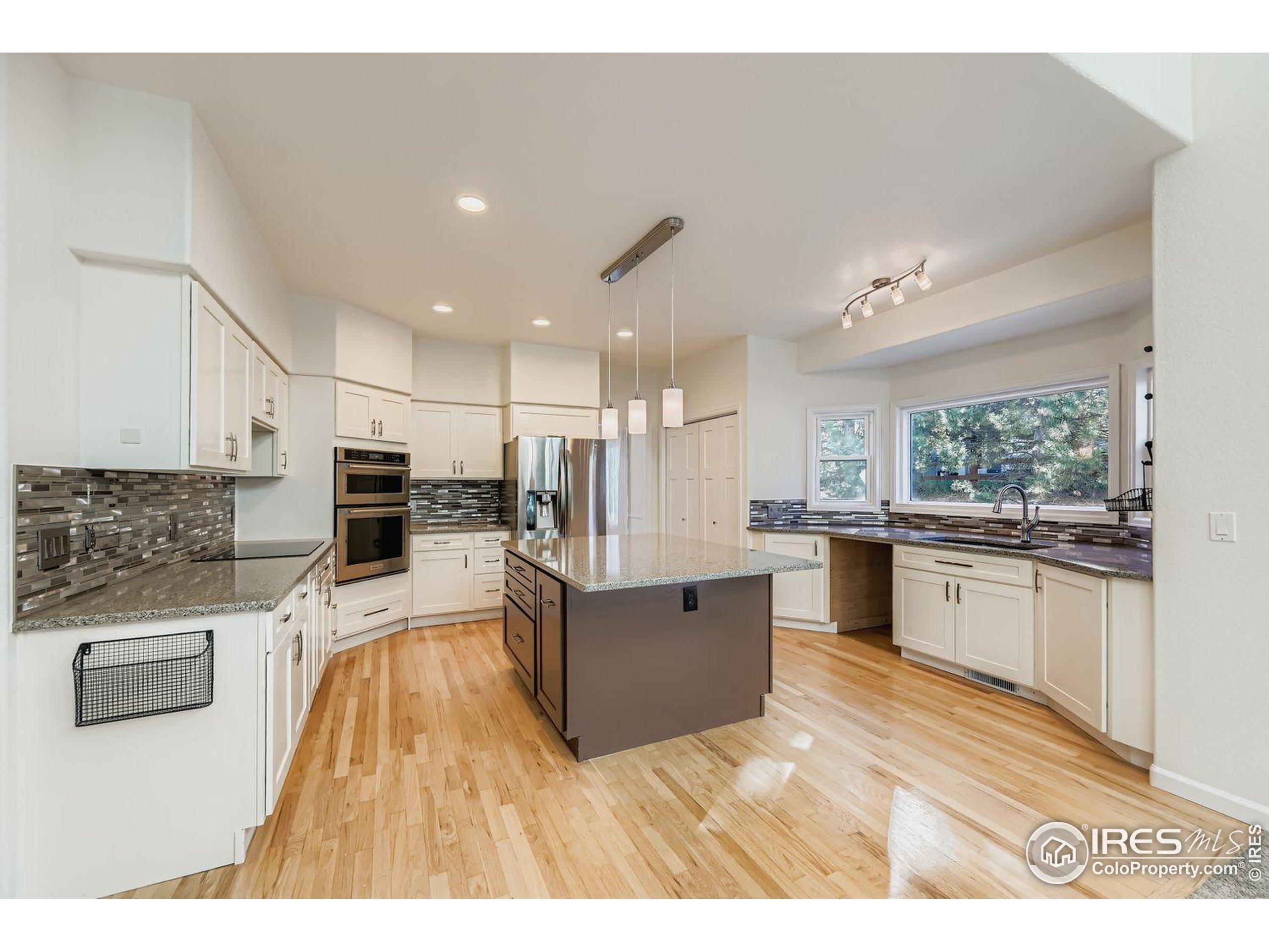 2062 Ridgeview Drive Longmont, CO 80504 - Photo 9 of 29 a large white kitchen with stainless steel appliances kitchen island granite countertop a large counter top a stove and a sink
