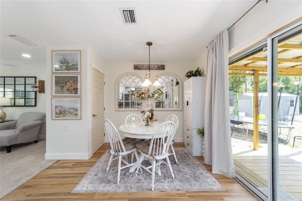 9040 Southwest 209th Circle Dunnellon, FL 34431 - Photo 15 of 55 a dining room with furniture a chandelier and wooden floor