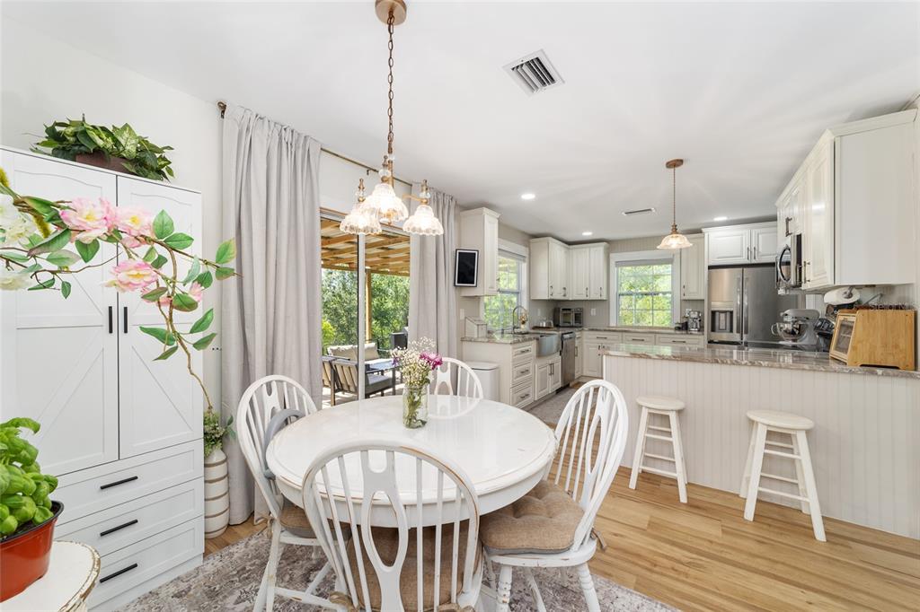 9040 Southwest 209th Circle Dunnellon, FL 34431 - Photo 16 of 55 a view of a dining room and livingroom with furniture wooden floor a chandelier