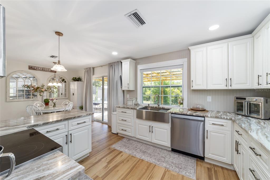 9040 Southwest 209th Circle Dunnellon, FL 34431 - Photo 22 of 55 a kitchen with white cabinets appliances wooden floor and a window
