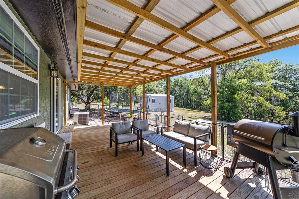 9040 Southwest 209th Circle Dunnellon, FL 34431 - Photo 35 of 55 a view of a patio with lawn chairs next to a yard