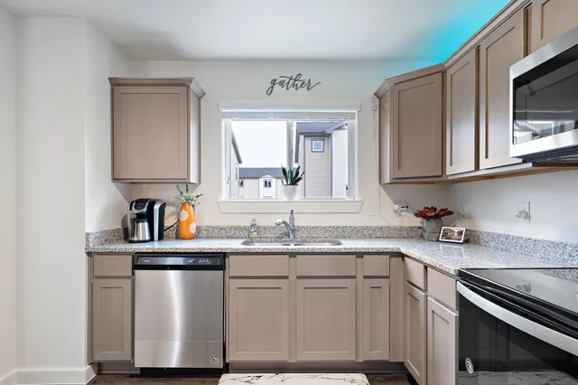 a kitchen with stainless steel appliances granite countertop a sink stove and microwave