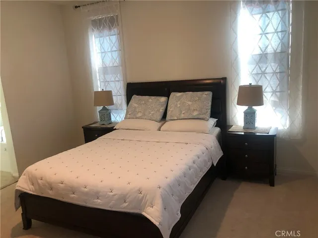 a large bed sitting in a bedroom next to a window and a mirror