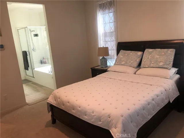 a bed sitting in a bedroom next to a window