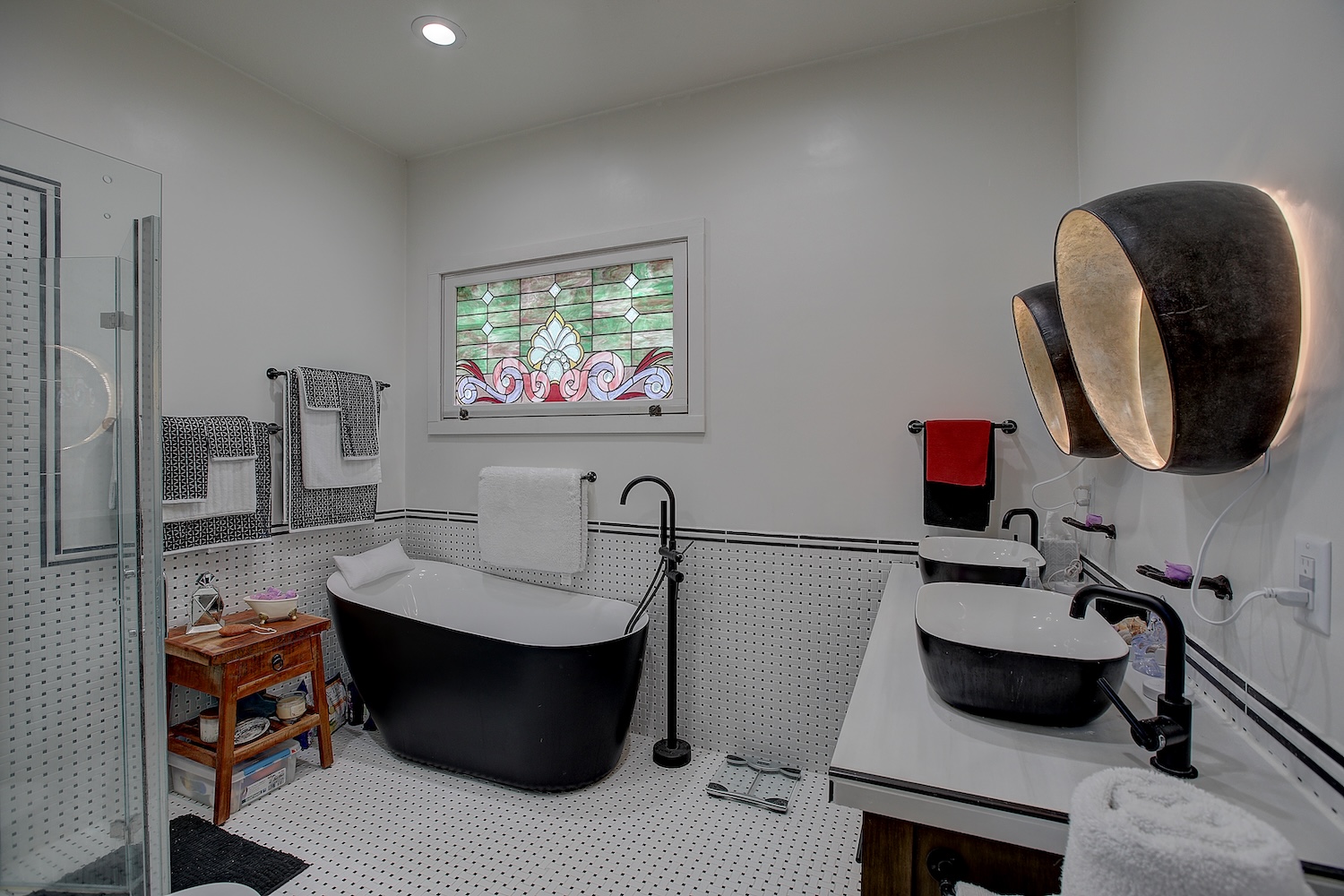 1903 South Austin Avenue Georgetown, TX 78626 - Photo 10 of 40 What a delightful space to take care of self care. Soak away the chaos of the day in the soaking tub. Or the glass shower with bifold door, dual vanity, and the stained glass window that allows light in, but keeps the space private.