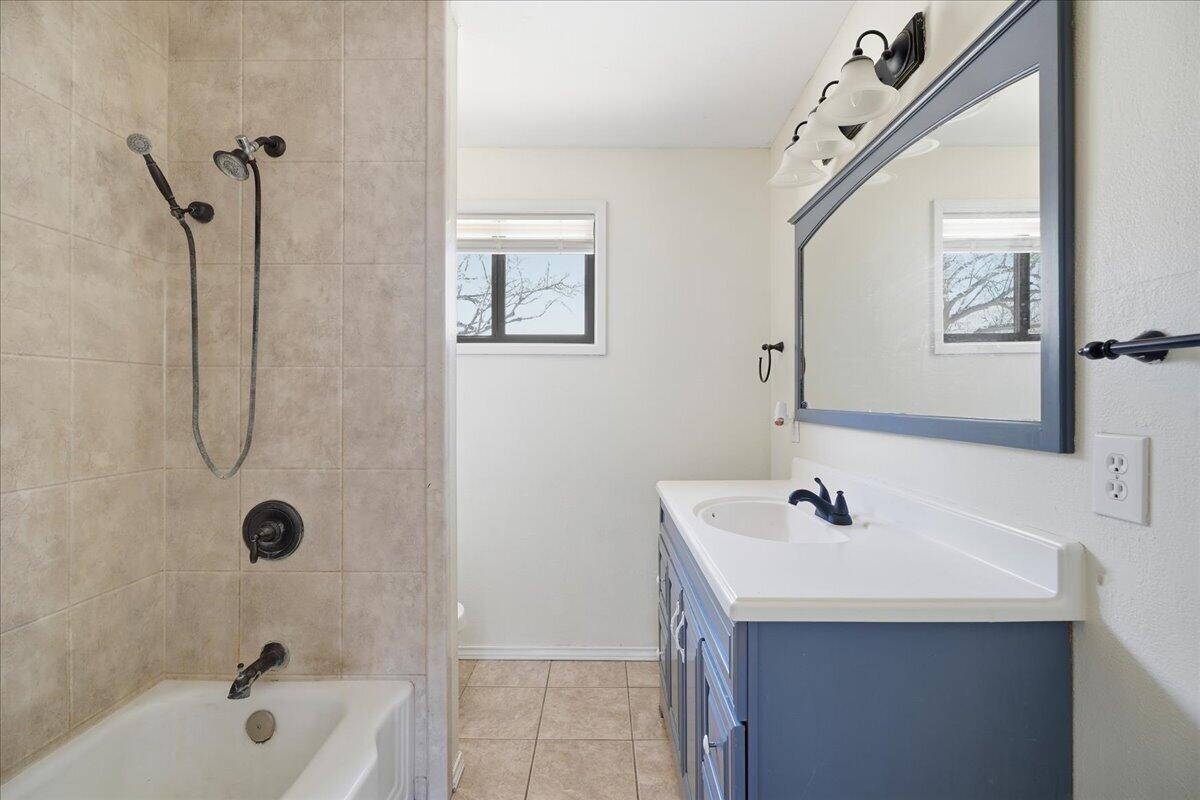 2706 68th Street Lubbock, TX 79413 - Photo 17 of 20 a bathroom with a sink a mirror and a bathtub