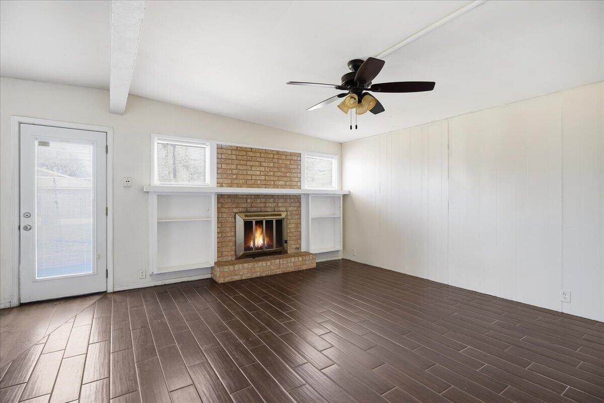 2706 68th Street Lubbock, TX 79413 - Photo 4 of 20 a view of a livingroom with wooden floor and a fireplace