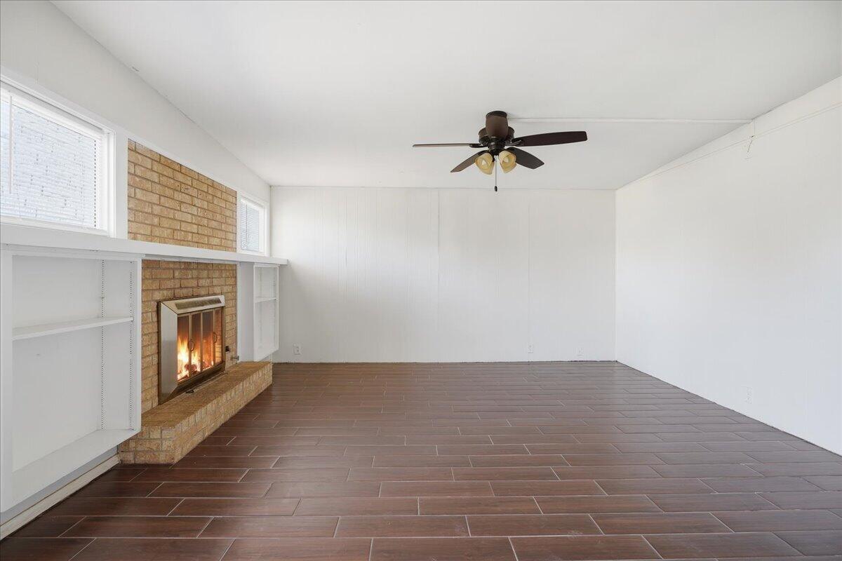 2706 68th Street Lubbock, TX 79413 - Photo 6 of 20 a view of an empty room with a fireplace and a window