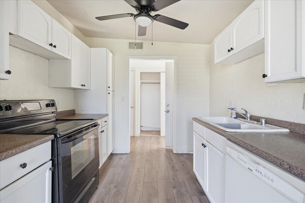 2706 68th Street Lubbock, TX 79413 - Photo 7 of 20 a kitchen with a sink stove and cabinets