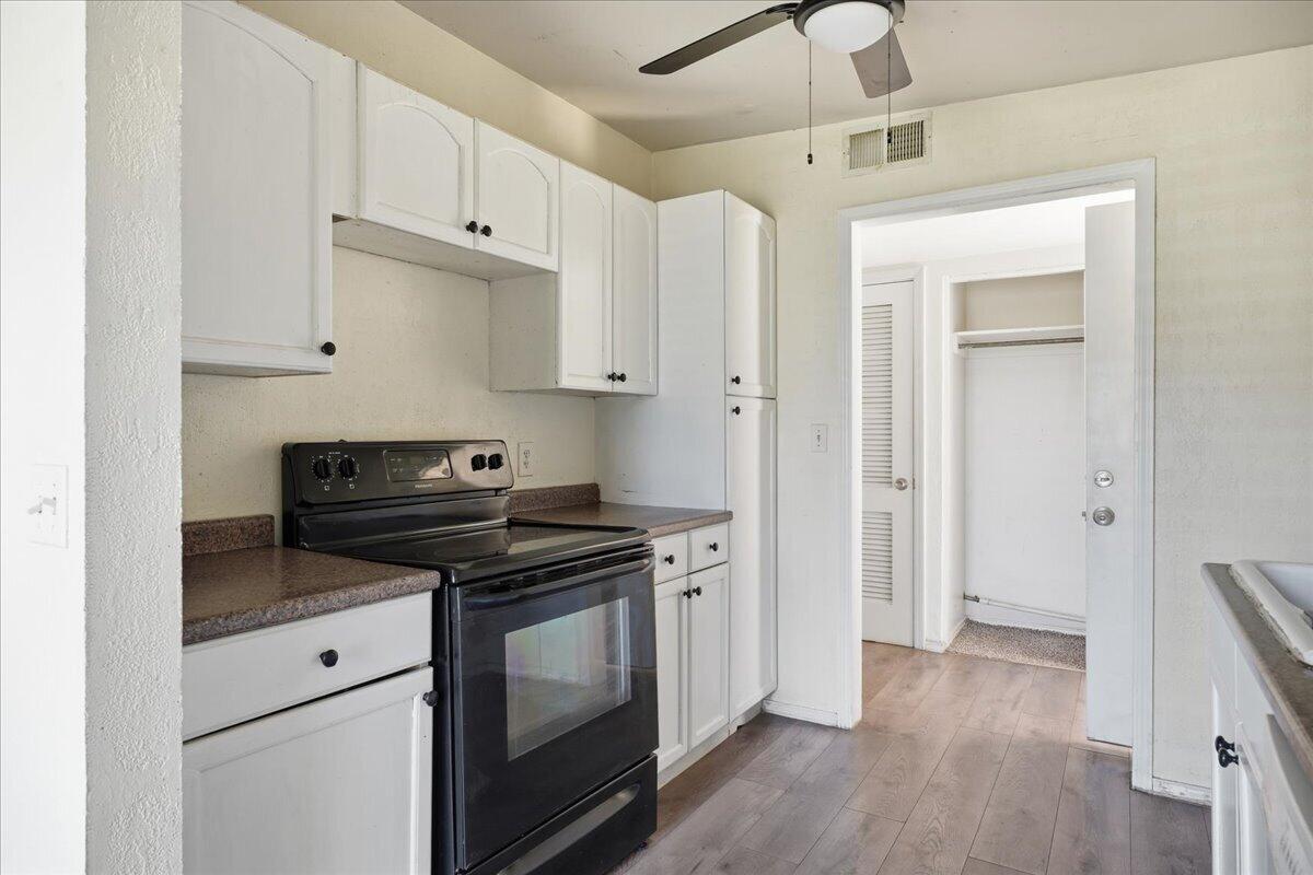 2706 68th Street Lubbock, TX 79413 - Photo 8 of 20 a kitchen with stainless steel appliances a stove and white cabinets