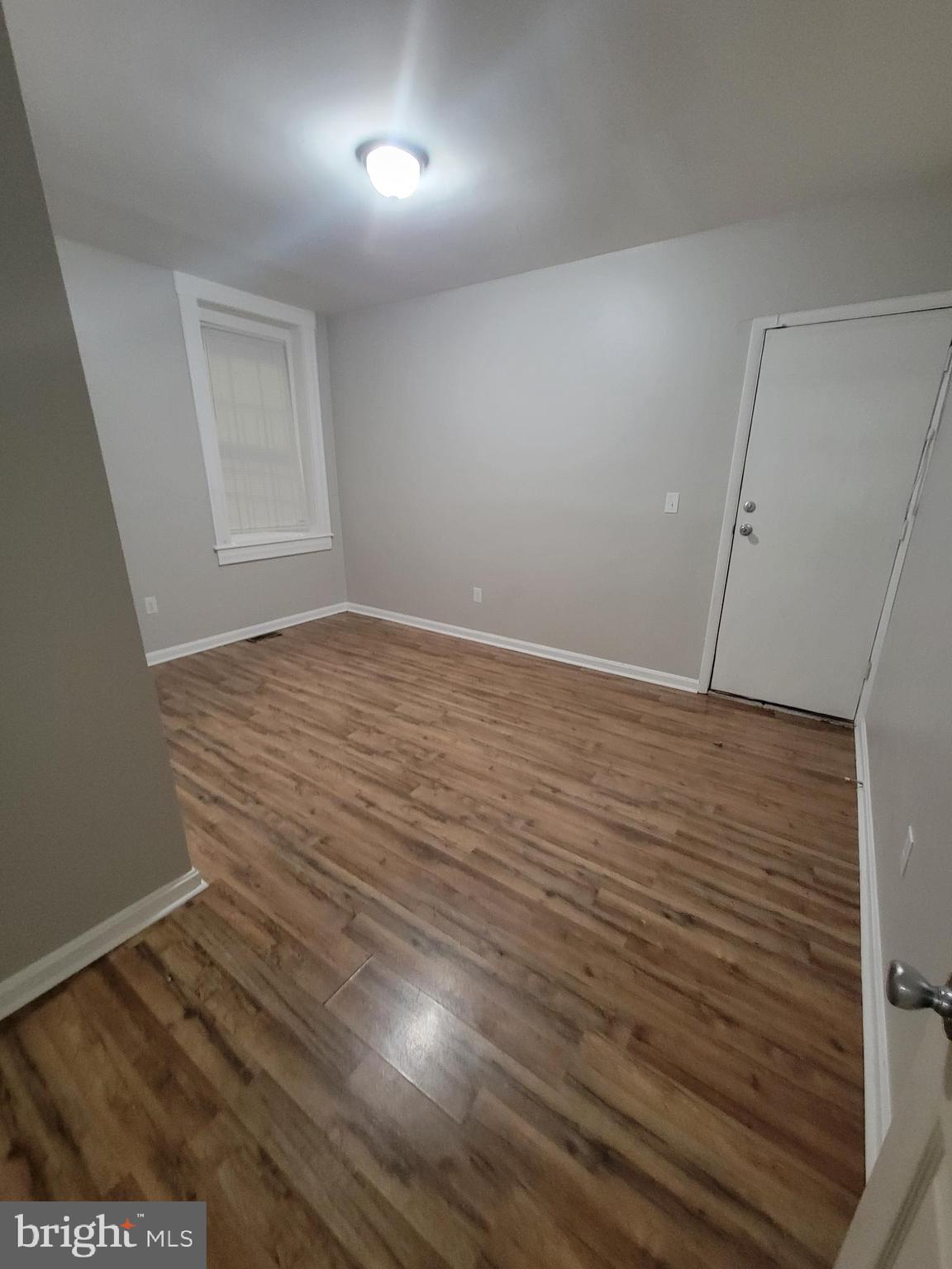 1217 Hollins Street, Unit 1 Baltimore, MD 21223 - Photo 2 of 6 wooden floor in an empty room