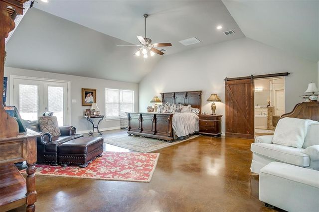 a bedroom with furniture and a large window