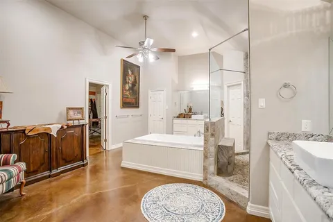 a spacious bathroom with a granite countertop sink a mirror and shower