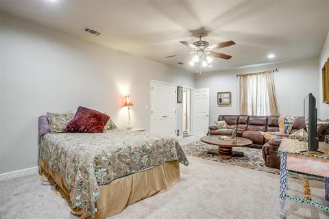a bedroom with bed couches and a flat tv screen