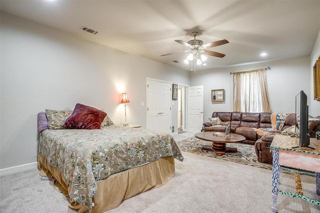 a bedroom with bed couches and a flat tv screen