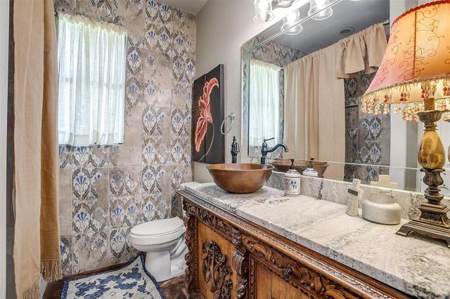 a bathroom with a granite countertop sink a toilet and a mirror