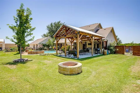 a view of a swimming pool with lawn chairs and plants
