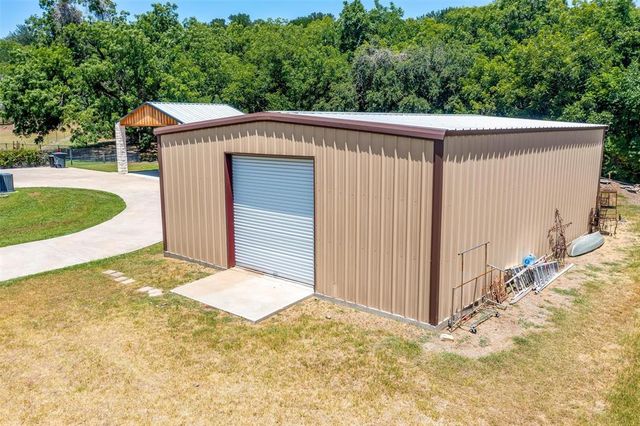 a view of a small house with wooden fence