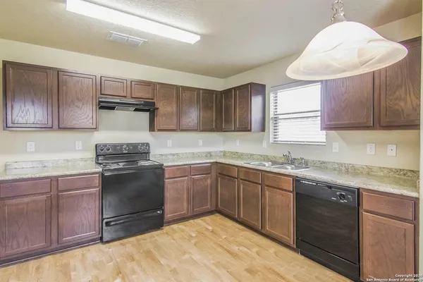 a kitchen with granite countertop a sink stainless steel appliances and cabinets