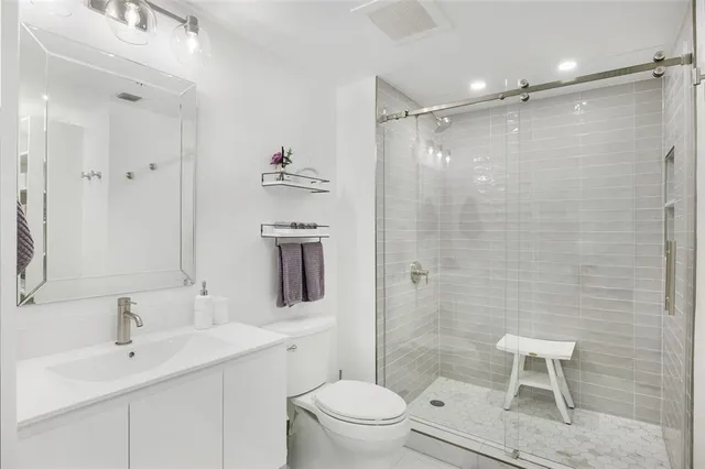 a bathroom with a sink toilet a mirror and shower