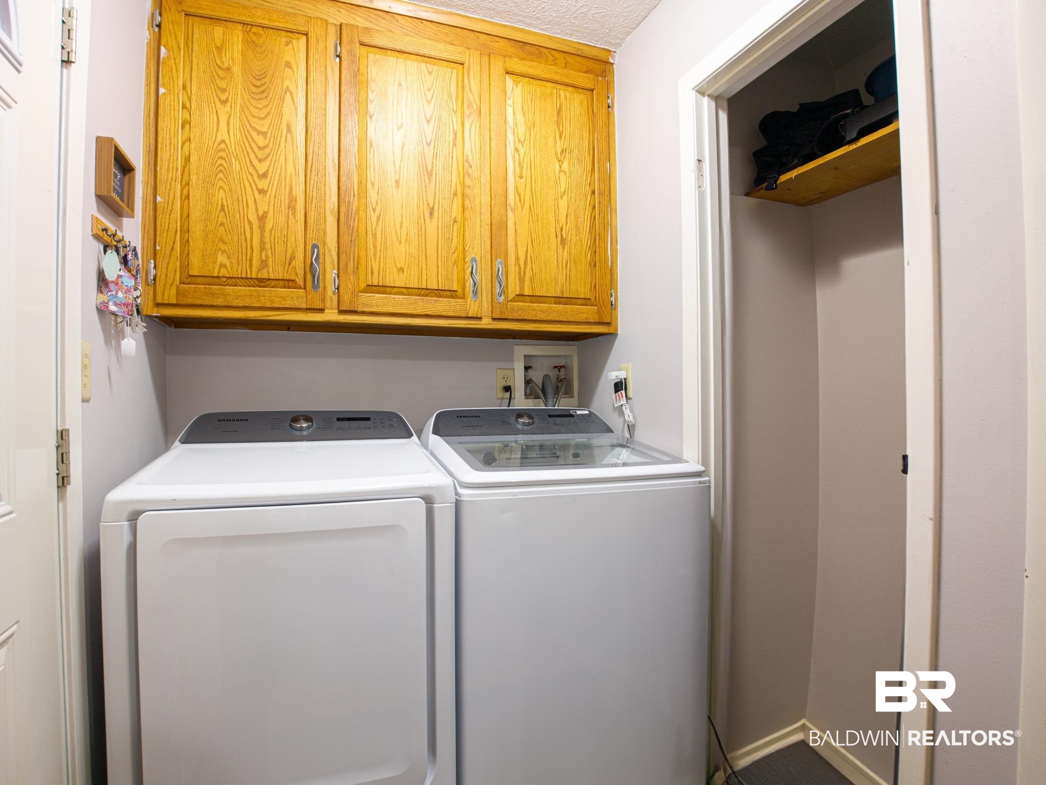1563 Valencia Drive Lillian, AL 36549 - Photo 10 of 27 Laundry room featuring washing machine and dryer and cabinet space