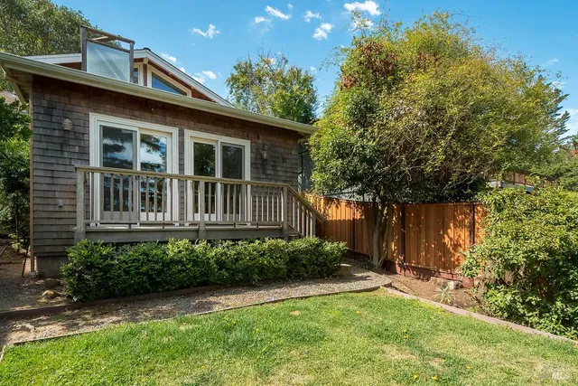 a balcony with wooden floor and yard in the back