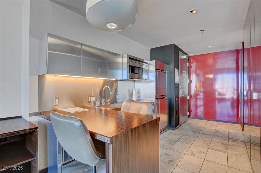 4381 West Flamingo Road, Unit 1206 Las Vegas, NV 89103 - Photo 4 of 27 Kitchen with a sink, appliances with stainless steel finishes, and light marble finish flooring