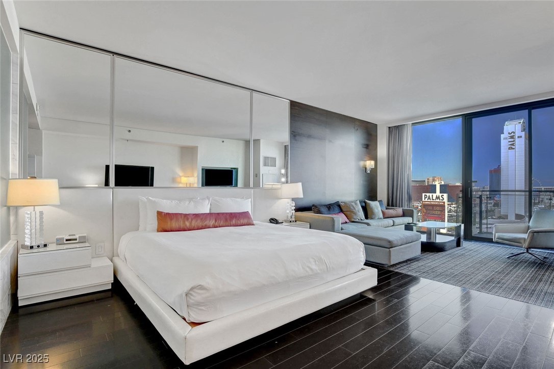 4381 West Flamingo Road, Unit 1206 Las Vegas, NV 89103 - Photo 5 of 27 Bedroom with floor to ceiling windows and wood finished floors