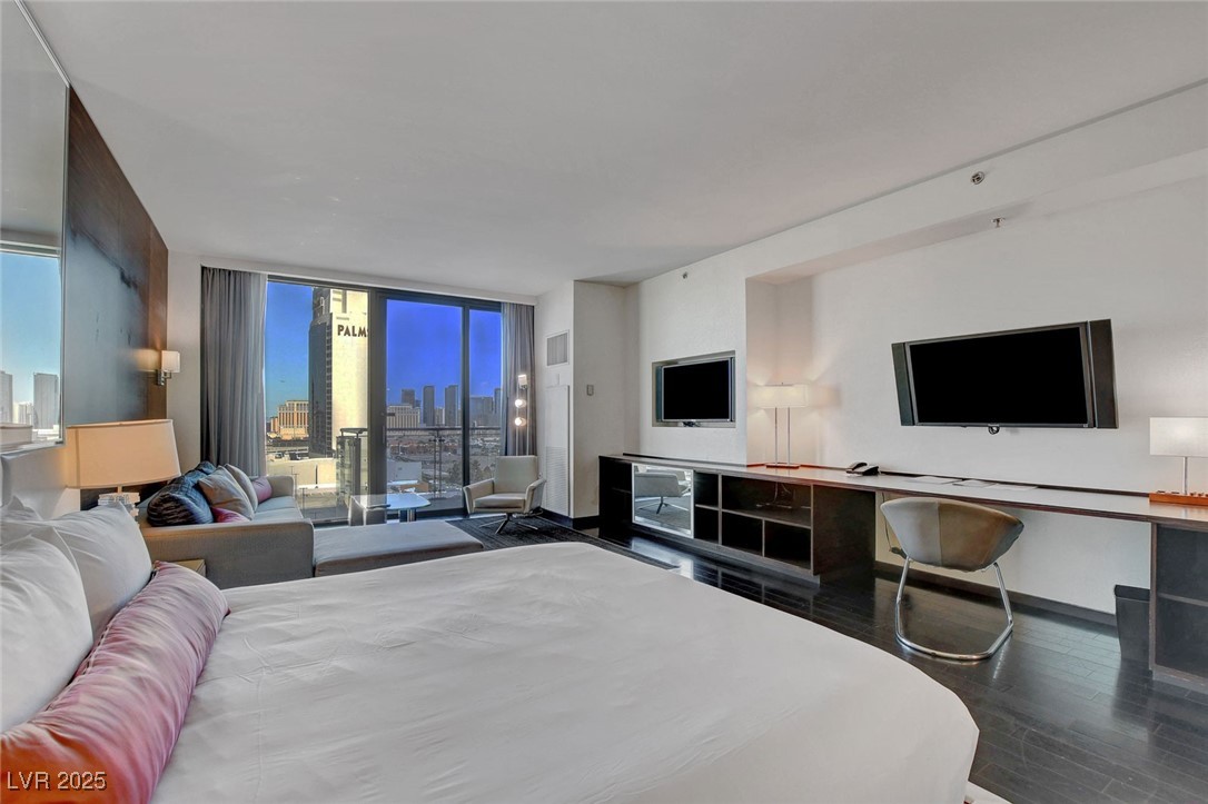 4381 West Flamingo Road, Unit 1206 Las Vegas, NV 89103 - Photo 6 of 27 Bedroom with wood finished floors, expansive windows, and baseboards