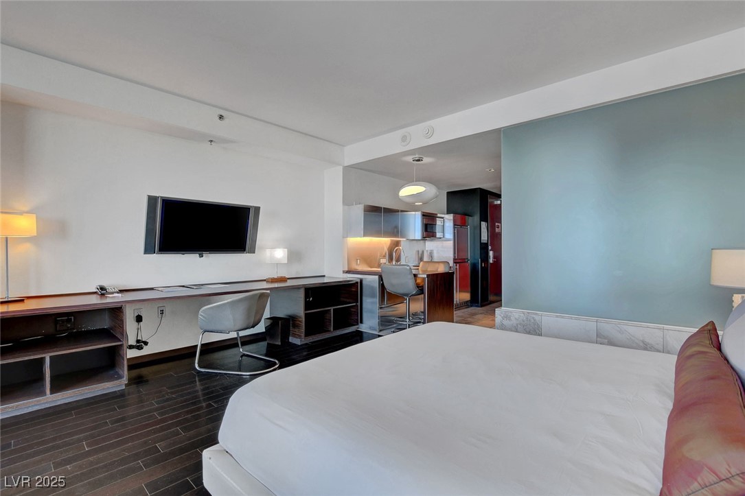 4381 West Flamingo Road, Unit 1206 Las Vegas, NV 89103 - Photo 7 of 27 Bedroom with wood finished floors, stainless steel fridge, and baseboards