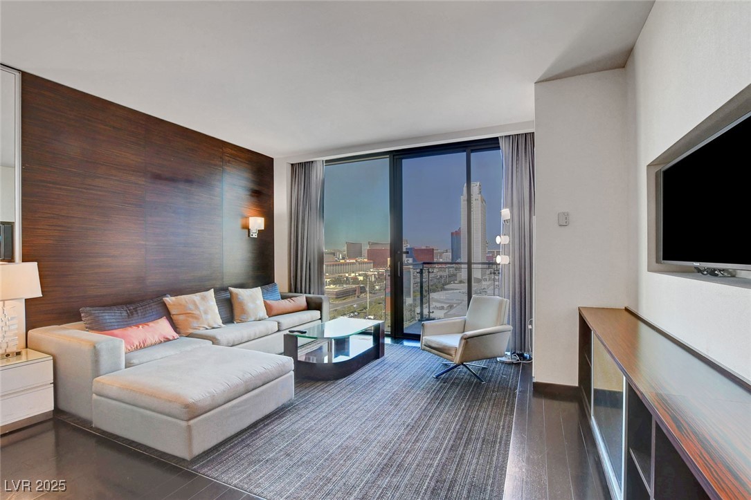 4381 West Flamingo Road, Unit 1206 Las Vegas, NV 89103 - Photo 8 of 27 Living area with floor to ceiling windows and wood finished floors
