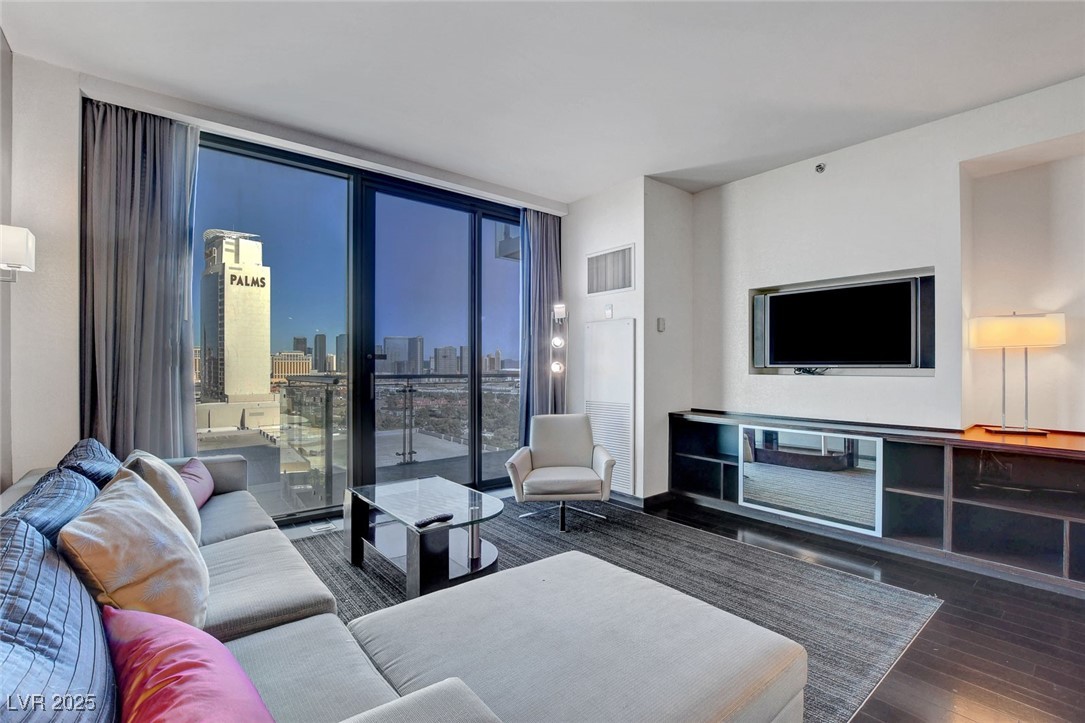 4381 West Flamingo Road, Unit 1206 Las Vegas, NV 89103 - Photo 9 of 27 Living area with a wall of windows and wood finished floors