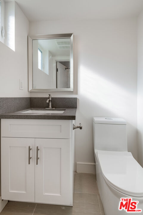 1663 Sargent Court Los Angeles, CA 90026 - Photo 11 of 20 a bathroom with a granite countertop toilet sink and mirror
