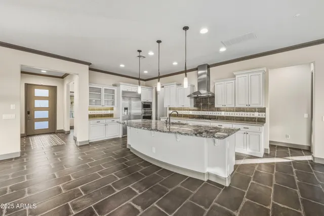 a kitchen with stainless steel appliances granite countertop a stove a sink and a refrigerator