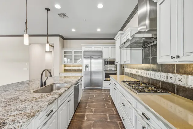 a kitchen with stainless steel appliances granite countertop a sink and a stove
