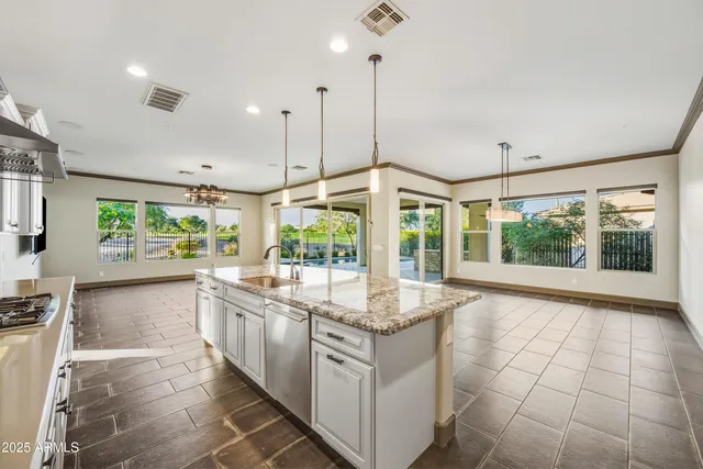 a kitchen with stainless steel appliances granite countertop a stove a sink and a large window