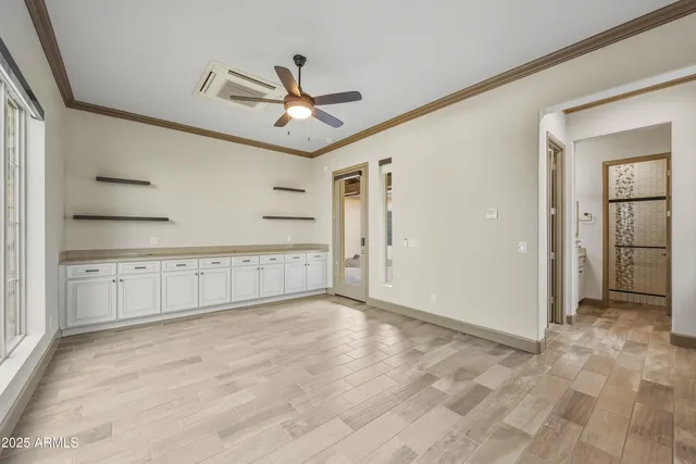 an empty room with fan and windows