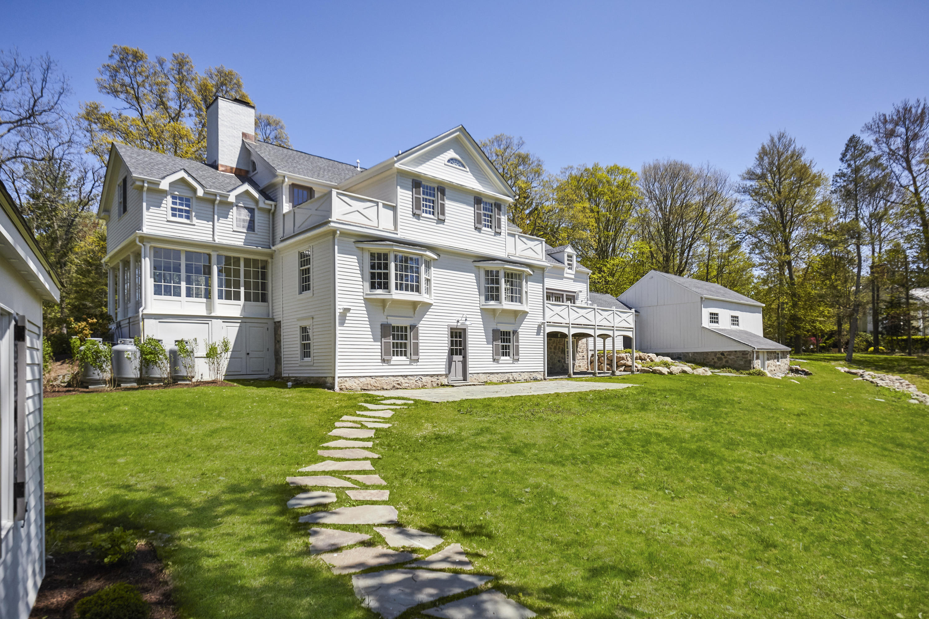 756 Ponus Ridge Road New Canaan, CT 06840 - Photo 40 of 54 a front view of a house with a garden