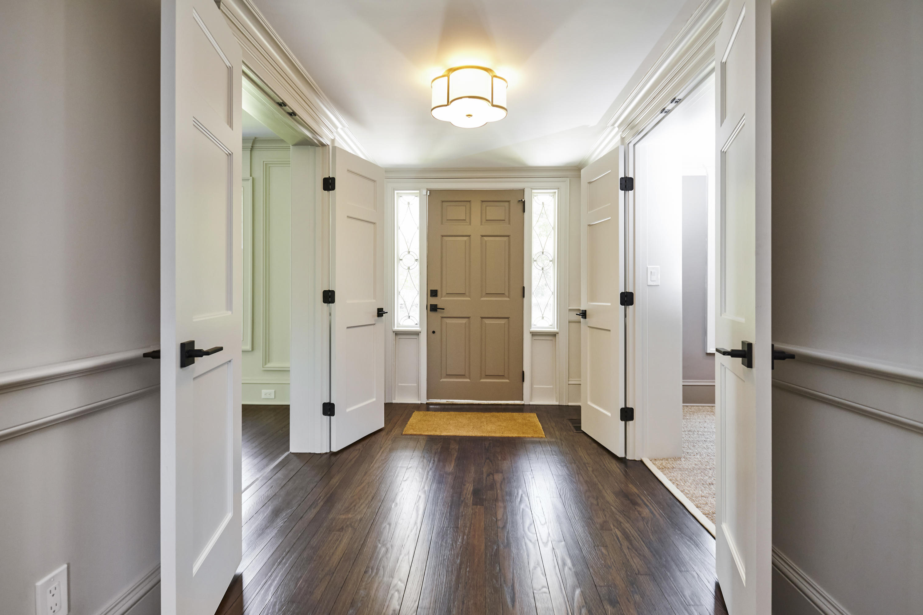 756 Ponus Ridge Road New Canaan, CT 06840 - Photo 49 of 54 a view of a hallway with wooden floor and a chandelier