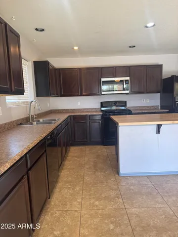 a kitchen with stainless steel appliances granite countertop a sink counter space cabinets and a large window
