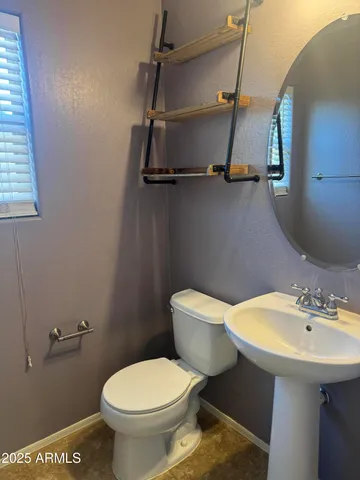 a bathroom with a toilet sink and mirror
