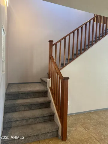 a view of staircase with wooden floor and white walls