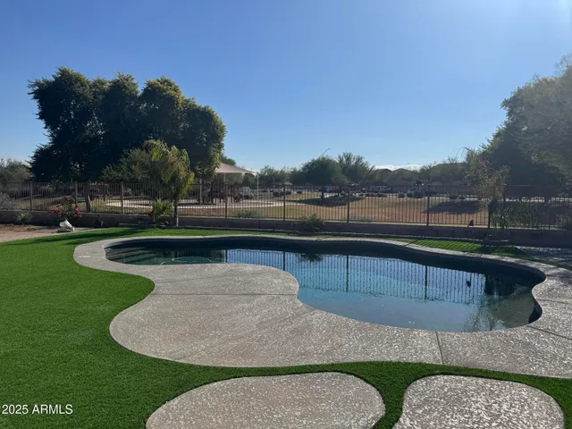 a view of swimming pool with seating space and lake view in back