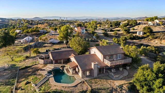 a living room with stainless steel appliances granite countertop furniture wooden floor and a kitchen view