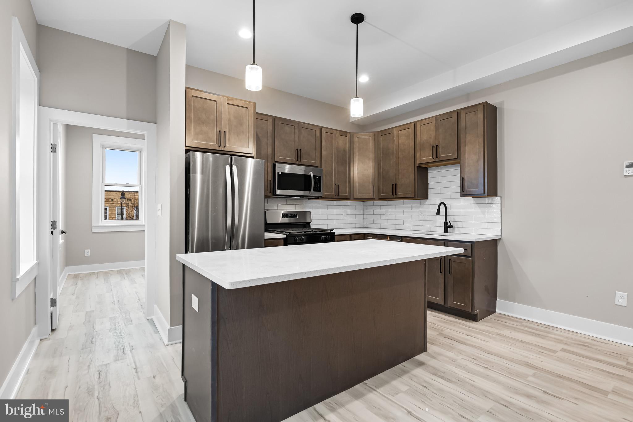 400 South Conkling Street, Unit 1 Baltimore, MD 21224 - Photo 4 of 18 a kitchen with kitchen island a sink stainless steel appliances and refrigerator